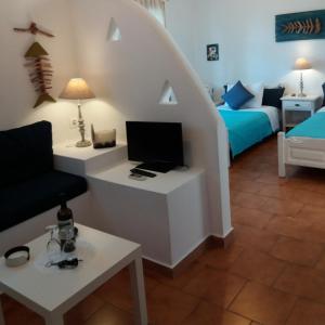 ein Wohnzimmer mit einem Zimmer mit einem Bett und einem Sofa in der Unterkunft Anofli Suites in Skopelos