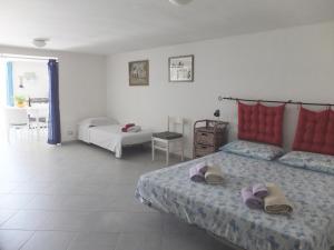 サンタ・クローチェ・カメリーナにあるPuntabraccetto Sunsetのベッドルーム1室(ビーチサンダル付きのベッド2台付)