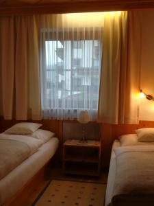 ラムサウ・イム・ツィラータールにあるApartment Martinaのベッド2台と窓が備わる小さな客室です。