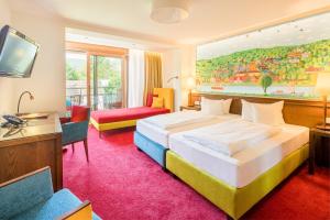 ローアにあるBoutique Hotel Bundschuh 3 Sterne Superiorのベッドとテレビが備わるホテルルームです。