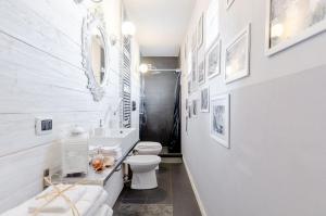 ein weißes Bad mit einem WC und einem Spiegel in der Unterkunft Il Cottage in Vigevano + 6 Fotos