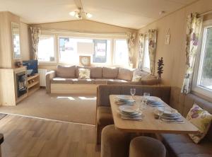 ein Wohnzimmer mit einem Tisch und einem Sofa in der Unterkunft Isle of Wight Caravan in Shanklin