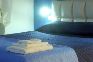 una pila de toallas sentadas encima de una cama en La casa di NOA NAPOLI in the heart of Vomero en Nápoles
