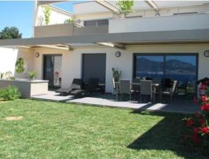 a house with a patio with a table and chairs at Appart 8 pers vue sur baie - Porticcio in Porticcio