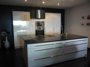 a kitchen with white cabinets and a black counter top at Appart 8 pers vue sur baie - Porticcio in Porticcio