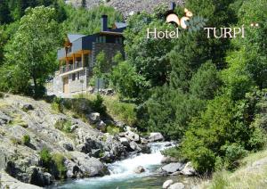 un hotel en una colina junto a un río en HOTEL TURPÍ, en Benasque