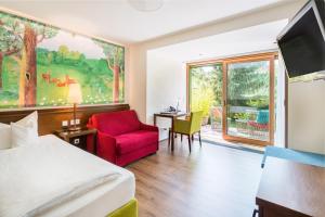 um quarto de hotel com uma cama e uma cadeira e uma janela em Boutique Hotel Bundschuh 3 Sterne Superior em Lohr