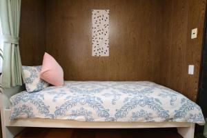 um quarto com uma cama com uma almofada cor-de-rosa em RINKA Minpaku / Vacation STAY 1105 em Osaka