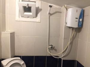 a bathroom with a toilet and a dispenser on the wall at Çatı Apartment in Istanbul