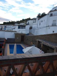 a patio with a pool and a table and umbrella at Apartamentos El Mirador in Bérchules