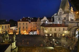 a city at night with people standing on a wall at Hotel U 3 Pstrosu in Prague
