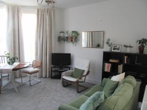 a living room with a couch and a table and a television at Central Living Apartment in Weston-super-Mare