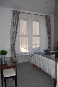 um quarto com uma cama e uma janela com uma cadeira em Central Living Apartment em Weston-super-Mare