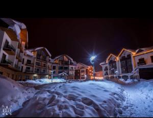 a group of buildings in the snow at night at Tatiana Gudauri in Gudauri