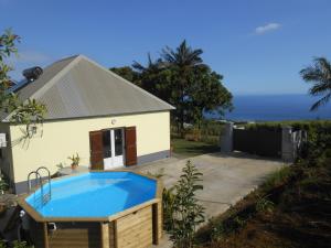 a house with a swimming pool in front of it at Gîte "Bassin Julien" in Saint-Joseph