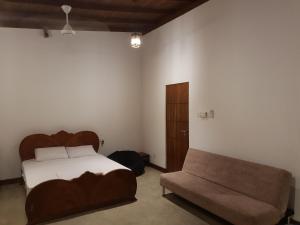 sypialnia z łóżkiem i kanapą w obiekcie Trellis Homes w Kolombo