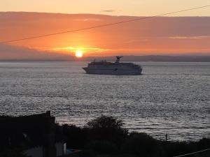 a cruise ship in the ocean at sunset at The Nook @ Drop Anchor in Portishead