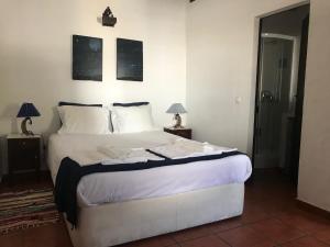 - une chambre avec un grand lit blanc et deux lampes dans l'établissement Monte Dos Vicentes, à Terena