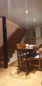 a dining room with a table and chairs and a staircase at Apartamento Rural la Muralla de Pedraza in Chavida