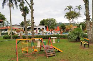 a park with a playground with a slide at Chalé Ponta das Canas in Florianópolis