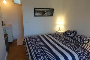 um quarto com uma cama com um edredão azul e branco em Sunny and quiet apartment em Paris