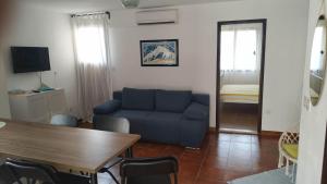 a living room with a blue couch and a table at Apartments Kupine in Bol