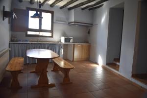 een keuken met een houten tafel, een tafel en een bank bij Apartamento Vivienda Sampietro in Radiquero