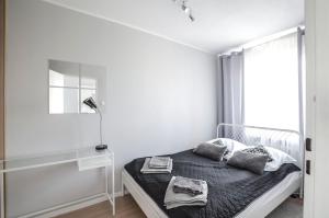 Habitación blanca con cama y ventana en Stanisława Dubois 29, Wrocław, en Wroclaw