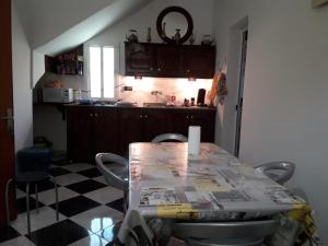 Una cocina con una mesa con sillas y una encimera. en BELLE MAISON AU COEUR DES MONTAGNES DE TAZA à moins de 10 minutes de l'AGORA PARK, en Taza