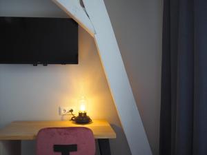 um quarto com uma mesa com um candeeiro e uma televisão em Lino City Hotel em Nijmegen