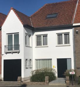 een wit huis met een bruin dak bij Vakantiewoning Margaux -free parking - Sauna in Brugge