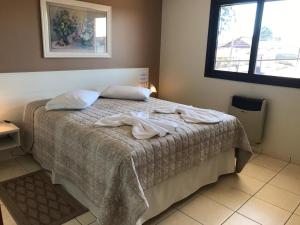 a bedroom with a bed with two towels on it at Center Hotel Cambará in Cambara do Sul