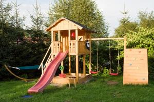 a small wooden play house with a slide at Domek Regionalny in Zakopane