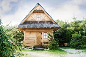 a small wooden cabin with a thatched roof at Domek Regionalny in Zakopane