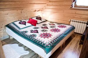 Domek Regionalny في زاكوباني: سرير في غرفة خشبية وعليه بطانية