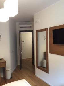 a room with a mirror and a tv on a wall at B&B COJBA in Gravina in Puglia