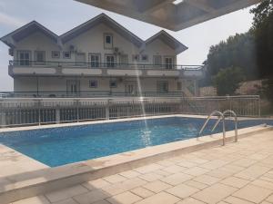 a house with a swimming pool in front of a house at Apartmani Nevena in Herceg-Novi