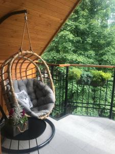 a porch swing with a chair on a patio at Apart-Center Pod Orłem in Zakopane