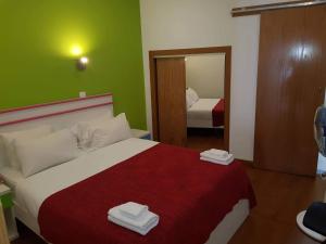 
a hotel room with a bed, desk and a lamp at Martim Moniz 28 Guest House in Lisbon
