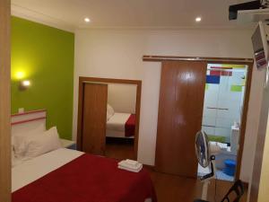 
a bedroom with a bed and a dresser at Martim Moniz 28 Guest House in Lisbon
