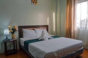 a bed with a stuffed animal on it in a bedroom at Adams View Hotel in Moalboal