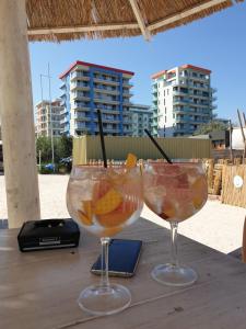two glasses with fruit in them sitting on a table at Bluemarina Apartamente in Mamaia