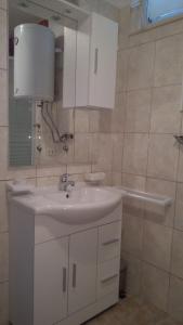 a bathroom with a white sink and a mirror at Apartments Matan in Sevid