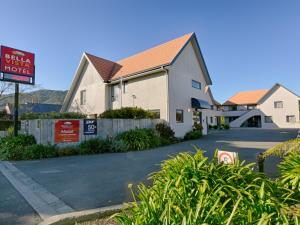 a white house with a sign on the side of it at Bella Vista Motel Greymouth in Greymouth