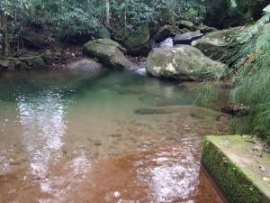 uma piscina de água com pedras num riacho em Fazenda Tapinuã em Silva Jardim