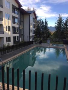 a large swimming pool in front of a building at Condominio Robles camino al volcan in Pucón