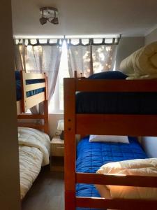 a bedroom with two bunk beds and a window at Condominio Robles camino al volcan in Pucón