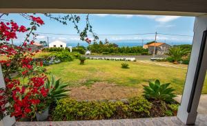 a view from a window of a yard with flowers at Casa Amaral in Santo António