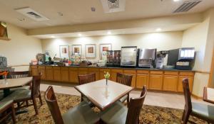 un restaurante con mesas, sillas y una barra en Country Inn & Suites by Radisson, Rock Falls, IL, en Rock Falls