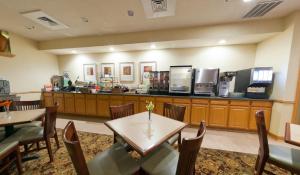 a restaurant with tables and chairs and a counter at Country Inn & Suites by Radisson, Rock Falls, IL in Rock Falls